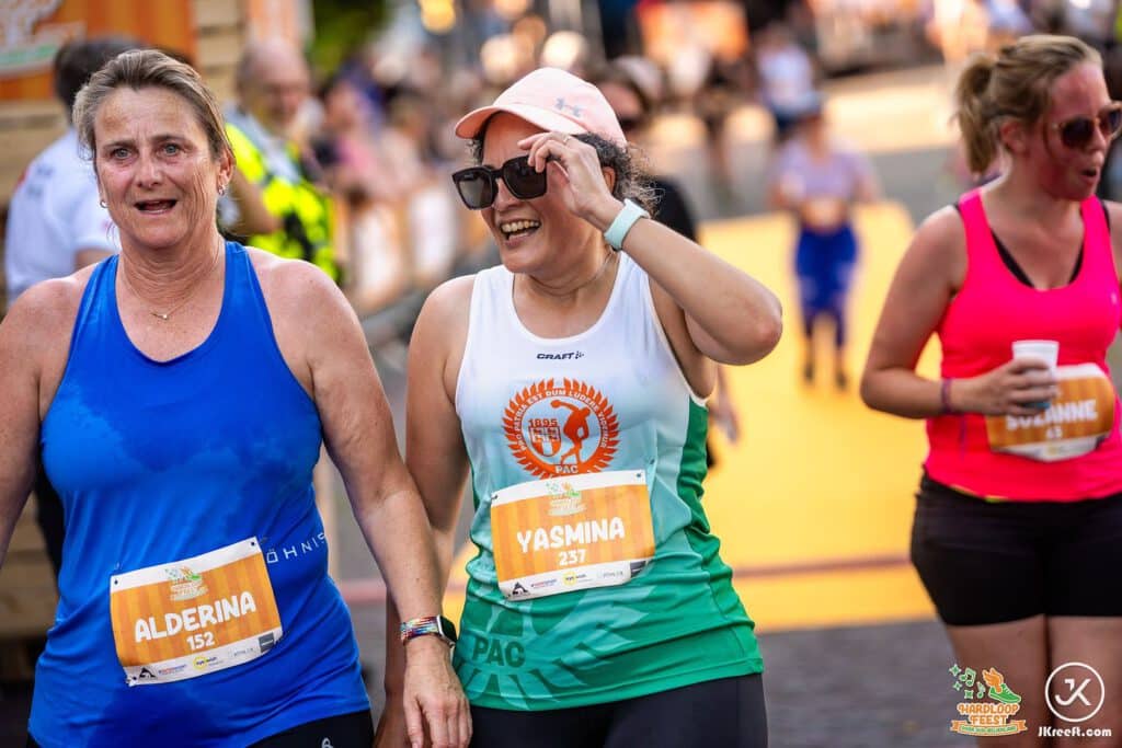 Twee lachende loopsters net over de finish