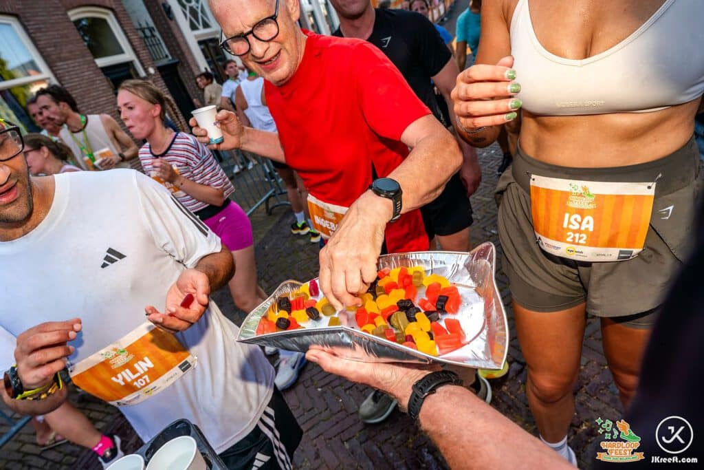 Lopers pakken snoep van een schaal na de finish