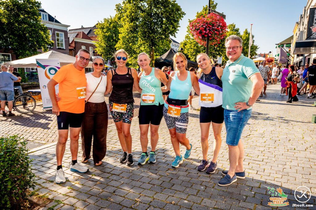 Vrienden poseren samen met hun startnummer na de loop